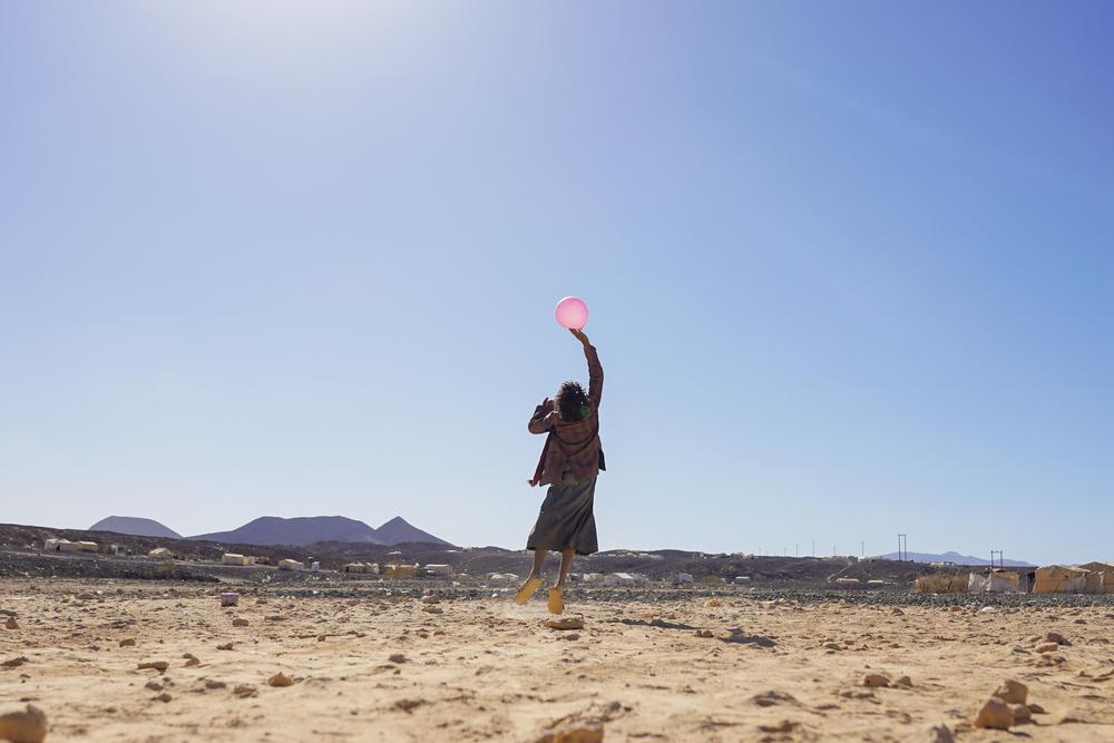 Un enfant joue avec un ballon dans le camp de personnes déplacées d'Al-Sweida à Marib, au Yémen. ©Hesham Al Hilali 