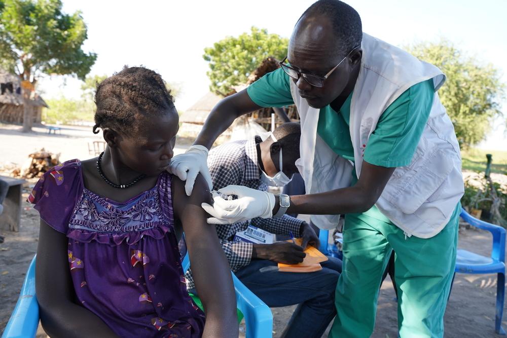 Bang Bol, superviseur de l'équipe infirmière de MSF, administre la première dose du vaccin contre l'hépatite E à une femme dans le village de Wangmok, dans l'État de Jonglei. © Gale Julius Dada/MSF