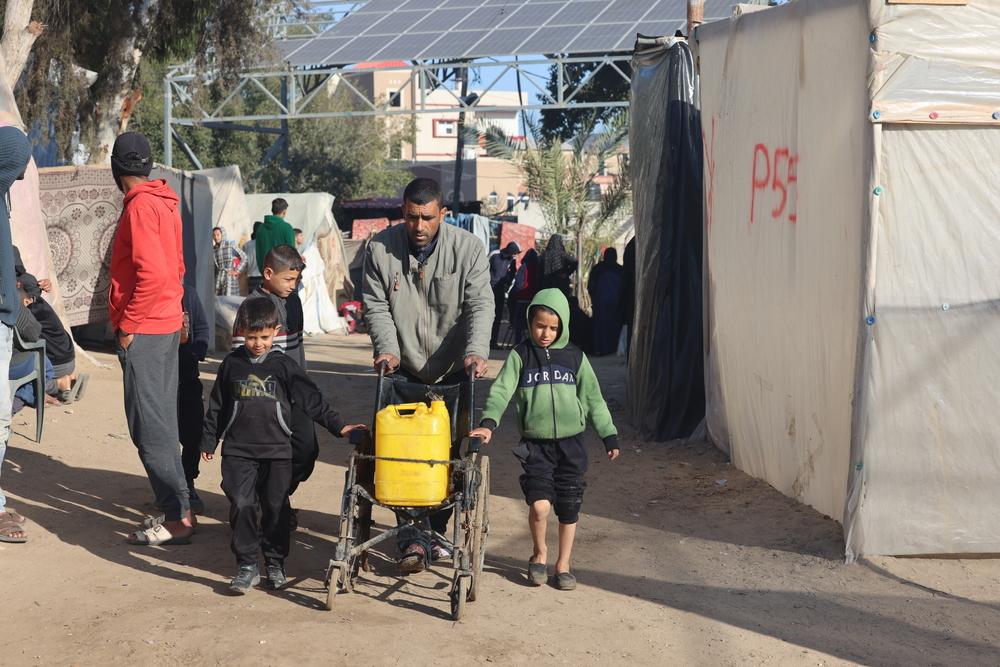 Un Palestinien transporte de l'eau avec ses deux enfants dans le quartier Al-Shaboura de la ville de Rafah, dans le sud de la bande de Gaza. ©Mohammed Abed