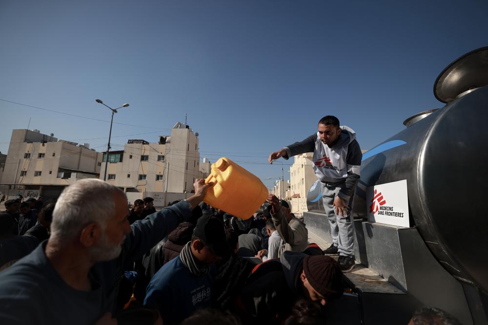 Un agent MSF chargé de l'eau et de l'assainissement, supervise une distribution d'eau aux personnes déplacées dans le quartier saoudien de Rafah, au sud de la bande de Gaza. ©Mohammed Abed 