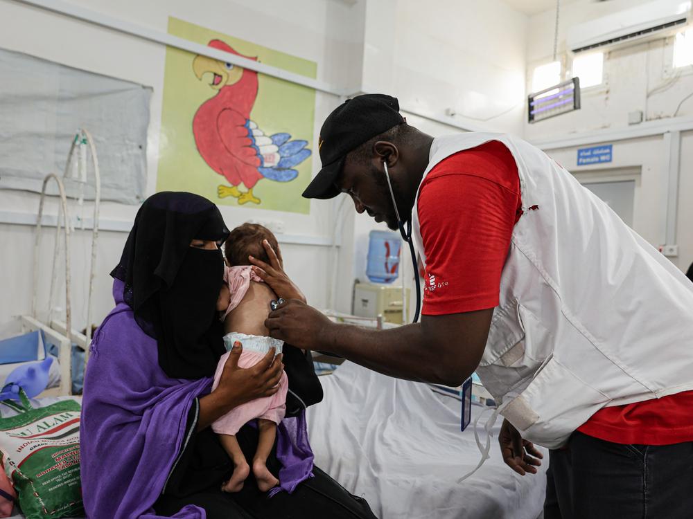 Le médecin MSF Bukar Galtimari examine le bébé Zaid dans le centre d'alimentation thérapeutique de l'hôpital général d'Abs, dans le gouvernorat de Hajjah. © Jinane Saad/MSF