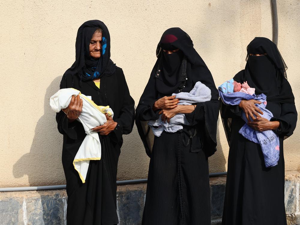 Des mères et des grands-mères tenant leur bébé devant le service de maternité soutenu par MSF à l'hôpital mère-enfant d'Al-Qanawis, dans le gouvernorat d'Al-Hudaydah. © Jinane Saad/MSF