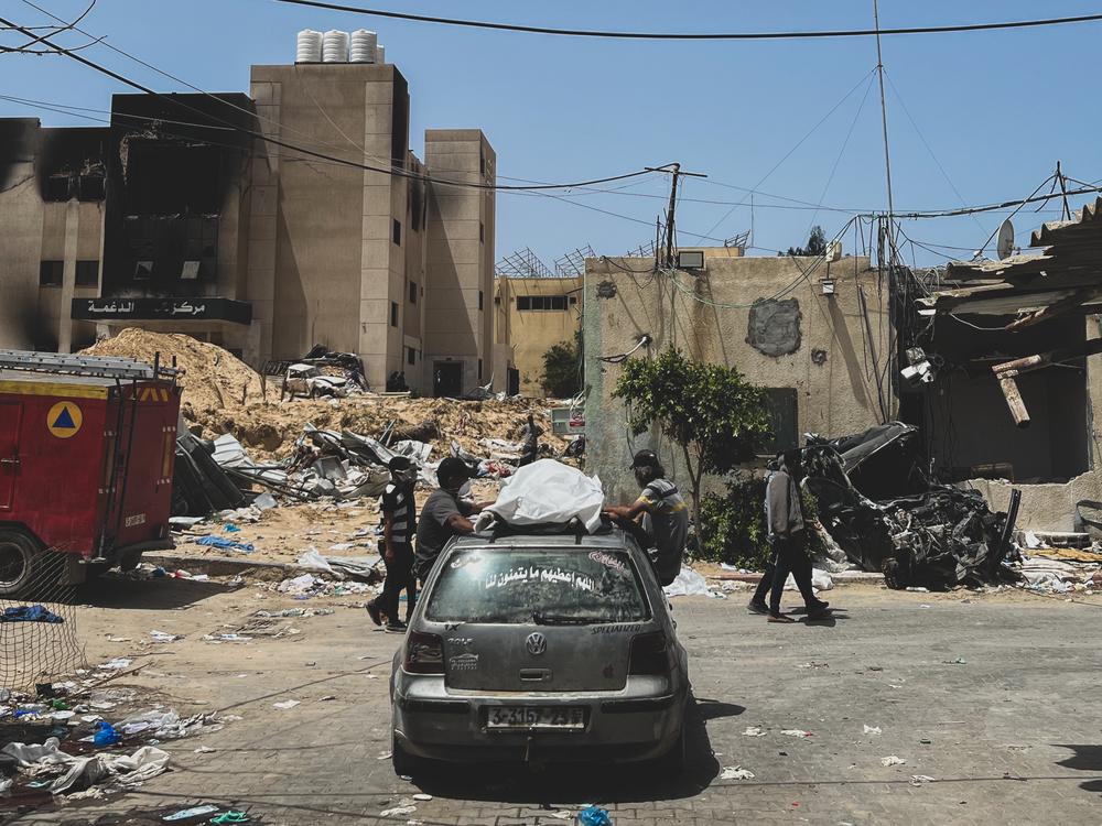 Palestine, Khan Younis, sud de Gaza, 22 avril 2024. Des Gazaouis cherchent à identifier les corps découverts dans une fosse commune située sur le terrain de l'hôpital Nasser. Le personnel de MSF a fourni 80 sacs mortuaires demandés par les équipes [de défense civile] chargées d'exhumer les corps. © Ben Milpas/MSF