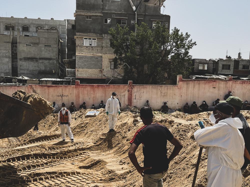 Palestine, Khan Younis, sud de Gaza, 22 avril 2024. Des Gazaouis cherchent à identifier les corps découverts dans une fosse commune située sur le terrain de l'hôpital Nasser. Le personnel de MSF a fourni 80 sacs mortuaires demandés par les équipes [de défense civile] chargées d'exhumer les corps. © Ben Milpas/MSF