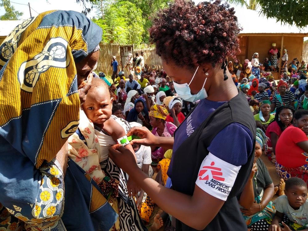Un membre du personnel de MSF mesure la circonférence du milieu et de la partie supérieure du bras d'un enfant pour vérifier s'il souffre de malnutrition à Meluco, dans la province de Cabo Delgado, au nord du Mozambique, le 19 février 2021. © MSF