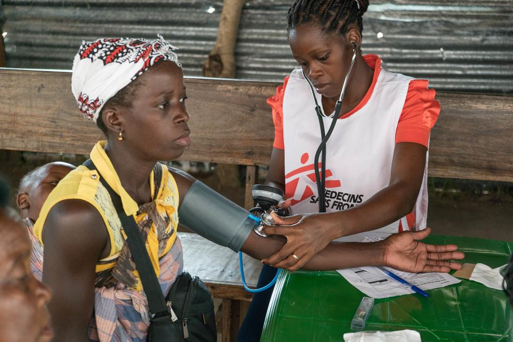 L'infirmière Cecília Passarinho Chigarisso Armando prend la tension artérielle d'un patient dans une clinique mobile de MSF dans le quartier d'Inhamizua. © Giuseppe La Rosa