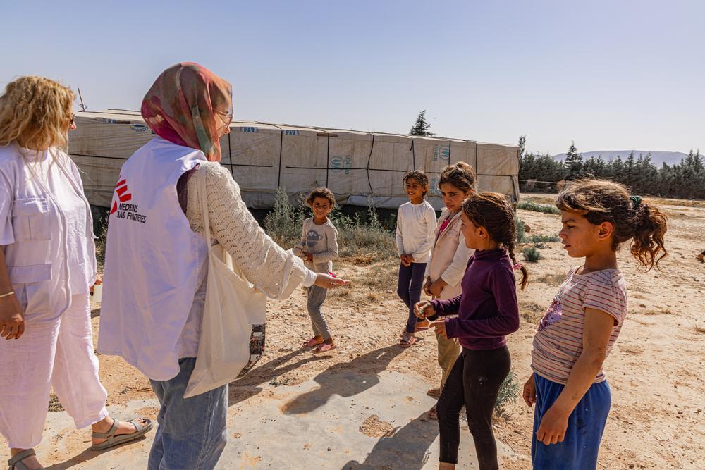 Les équipes de MSF sont accompagnées par des enfants alors qu'elles parcourent un campement informel à Qaa, au nord-est du Liban. La ville frontalière a connu une montée en puissance du sentiment anti-syrien, ce qui a eu un impact sur la capacité des réfugiés à accéder aux soins de santé. © Carmen Yahchouchi/MSF