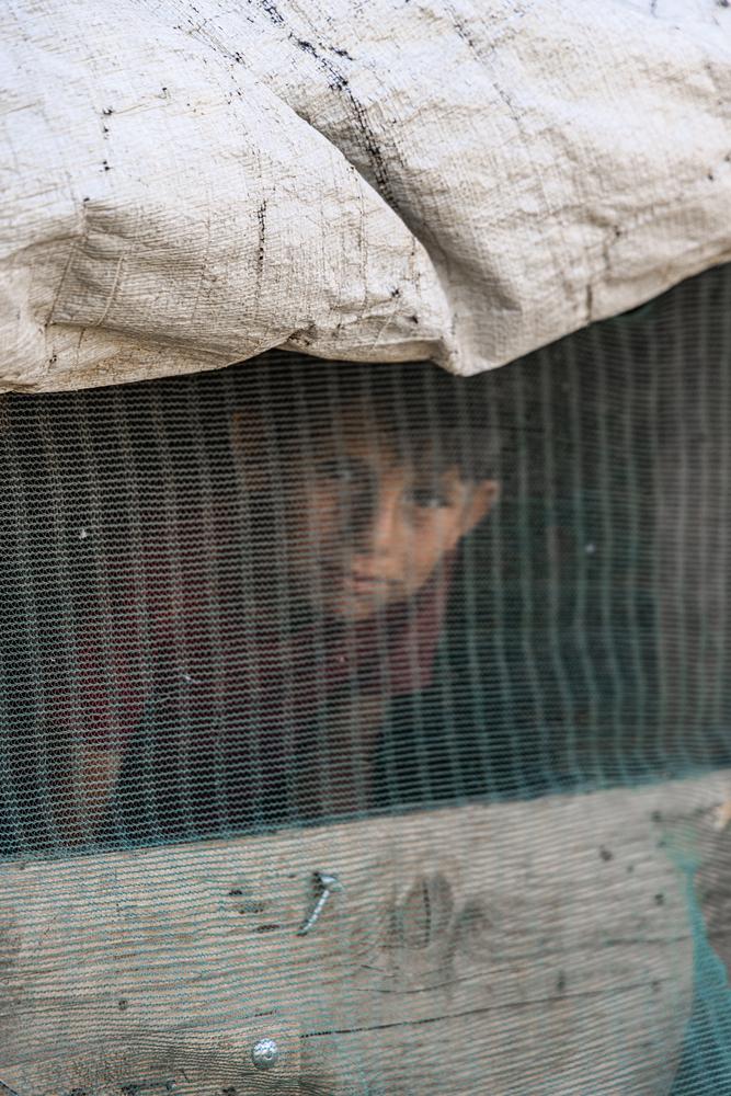 Un réfugié syrien regarde à travers l'ouverture de ventilation d'une tente. © Carmen Yahchouchi/MSF