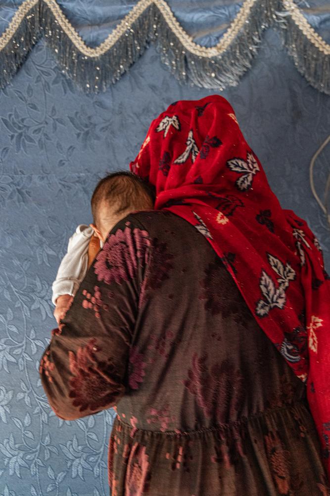 Une réfugiée syrienne tient le bébé d'un mois qu'elle a aidé à mettre au monde à Qaa, au nord-est du Liban.Les récentes mesures de sécurité et les restrictions aux points de contrôle ont eu un impact sur la capacité des réfugiés à accéder aux soins de santé, obligeant la communauté à se réunir pour un accouchement impromptu. © Carmen Yahchouchi/MSF