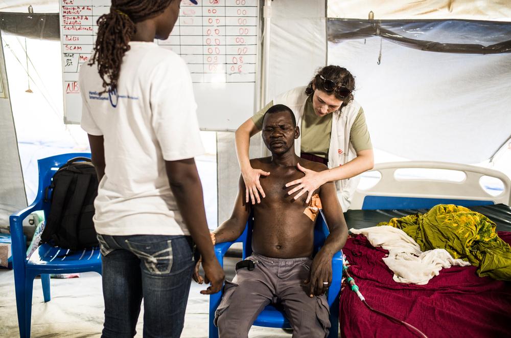 Alexandra, MSF physiotherapist, and Anne, Humanity and Inclusion (HI) assistant, look after Yasir in the MSF surgical unit at Adré hospital. MSF has teamed up with the NGO HI to provide physiotherapy and rehabilitation care for war-wounded patients operated on in Adré.© Corentin Fohlen/Divergence
