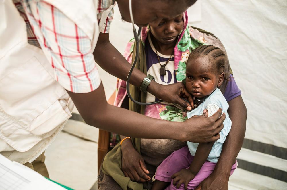 Consultation pédiatrique à la clinique ambulatoire de MSF dans le camp de transit d'Ambelia. Ashia Abdallah, 25 ans, enceinte, et sa fille Remas Abdallah, 4 ans, sont arrivées au Tchad il y a près de 9 mois. Les yeux de sa fille sont rouges et elle souffre de conjonctivite.© Corentin Fohlen/Divergence