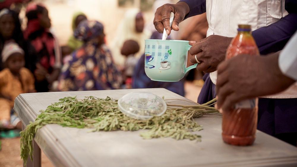 Maryam Muhammad, superviseur MSF de la promotion de la santé à Kebbi, tient une tasse lors d'une démonstration de la recette Tom Brown dans le village de Maishaika, dans l'État de Kebbi, au nord-ouest du Nigeria. Une centaine de femmes ont participé à cette démonstration. ©Georg Gassauer/MSF 