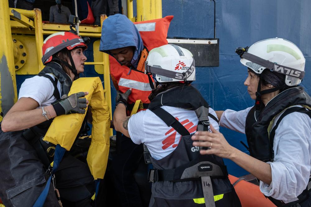 Les membres de l'équipe MSF Fulvia, Carolina et Nejma aident un survivant blessé à monter à bord du navire lors d'une opération de sauvetage