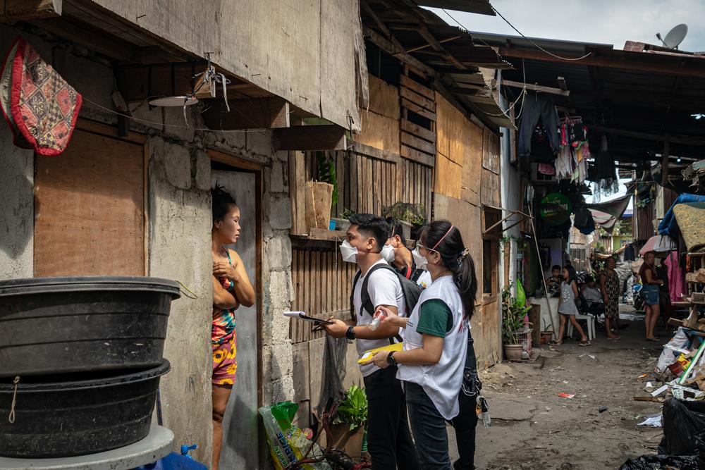 L'équipe de soutien aux patients de MSF parle à un résident de sa liste dans le Barangay 105 Aroma of Tondo dans la ville de Manille, aux Philippines, le 2 mars 2023.