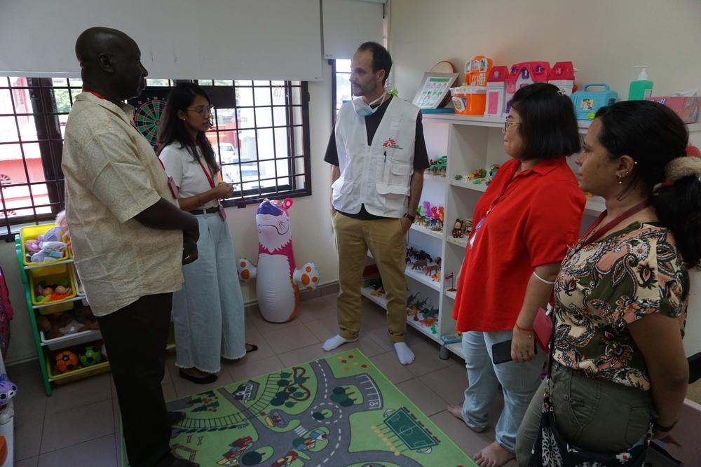 Le personnel de Médecins Sans Frontières explique au Dr Christos Christou, président de Médecins Sans Frontières International, le but et les activités menées dans la salle de thérapie par le jeu de la Klinik Mewah 6 à Butterworth, Penang, en Malaisie.
