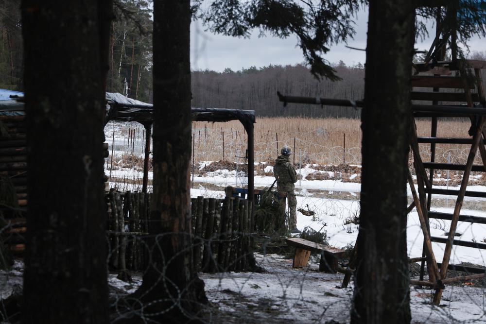 Un soldat polonais dans son camp, entre une chaire d'observation et une cabane en bois.