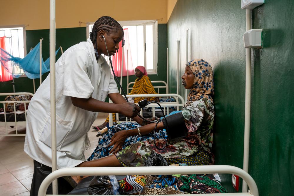 Samaboula Macalou, infirmière, prend les signes vitaux d'Oumou Sangaré, une femme qui vient d'accoucher au centre de santé communautaire C3 de Niono.