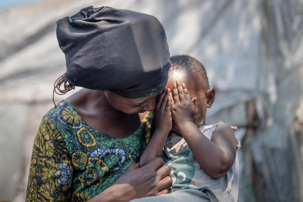 Tuliya sourit, tenant son fils Gadi dans ses bras dans le camp d'Elohim.