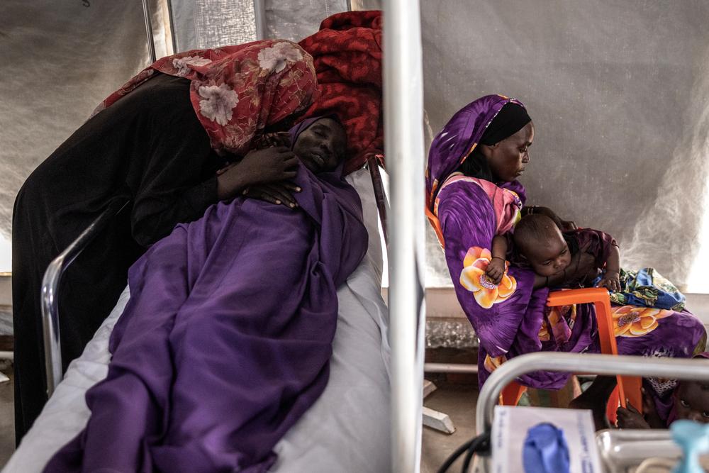 Sena Mahoobg, 16 ans (à gauche), réconforte sa mère, Amna Abdurahman, 35 ans, qui souffrait de fièvre et de gastro-entérite, aux urgences de l'hôpital MSF de Metche, dans l'est du Tchad, le 8 août 2024.