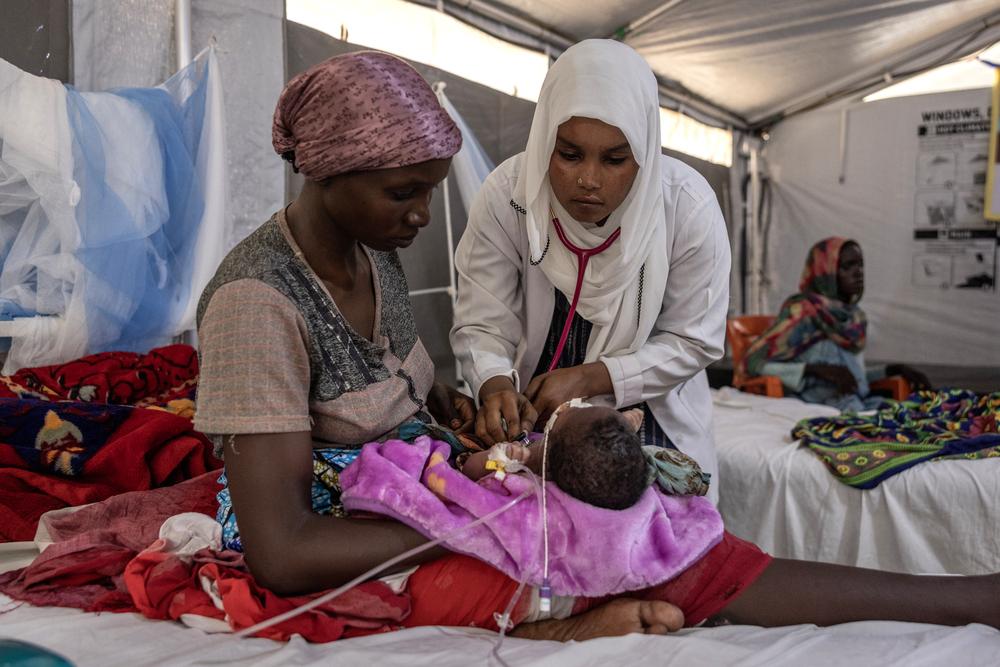 Le médecin soudanais Faiza Hamed Hangata, 24 ans, originaire d'El Geneina au Darfour, examine un enfant dans le service pédiatrique de l'hôpital MSF de Metche, dans l'est du Tchad, le 7 août 2024.