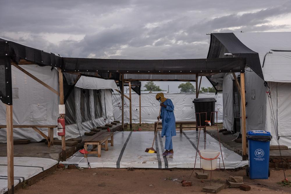 Une agent d'entretien travaille après la pluie à l’hôpital MSF de Metche, dans l’est du Tchad, le 7 août 2024. Le camp de Metche accueille environ 40 000 réfugiés soudanais qui ont fui les violences au Darfour. Finbarr O’Reilly/VII Photo.