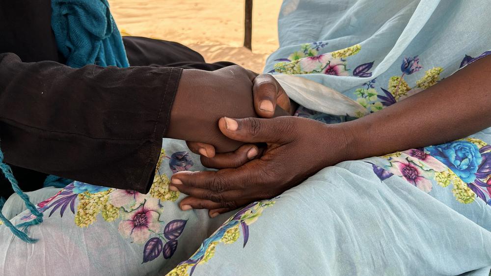 Nafissa tenant la main de sa fille Amira, toutes les deux vivent dans le camp de réfugiés d'Adré, au Tchad