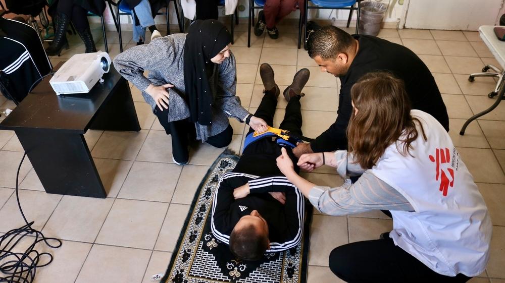 Un médecin de MSF dispense une formation pratique en soins préhospitaliers aux victimes de traumatismes dans la ville de Tulkarem, au nord de la Cisjordanie, où un groupe de volontaires est formé pour améliorer leurs compétences en matière d'intervention d'urgence.