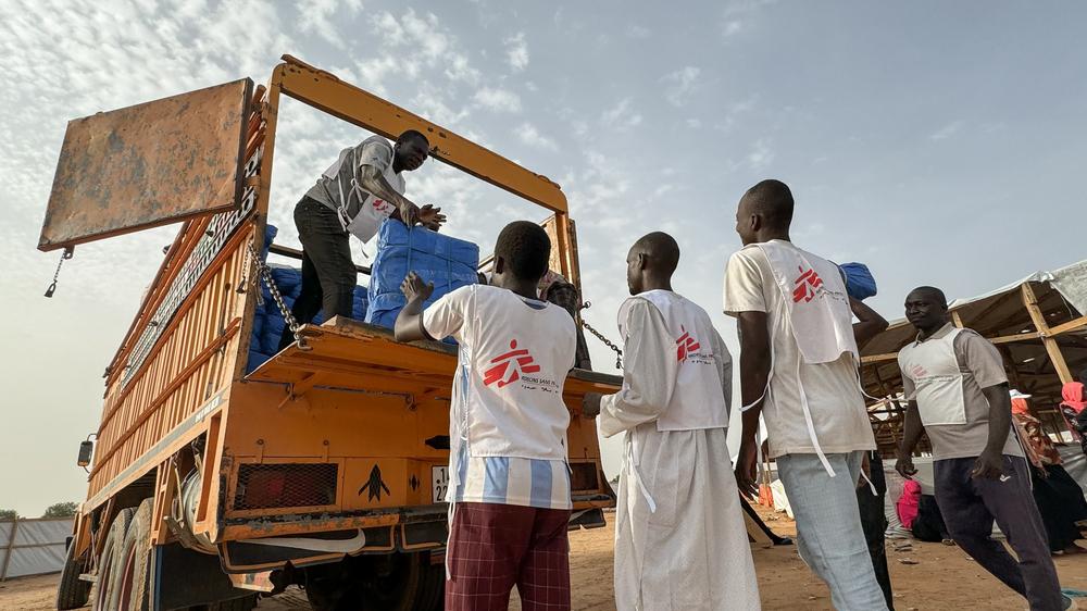 Un camion transportant des milliers de bâches en plastique, de moustiquaires et de savons est déchargé par les équipes MSF sur le site de distribution du camp de transit d'Adré.