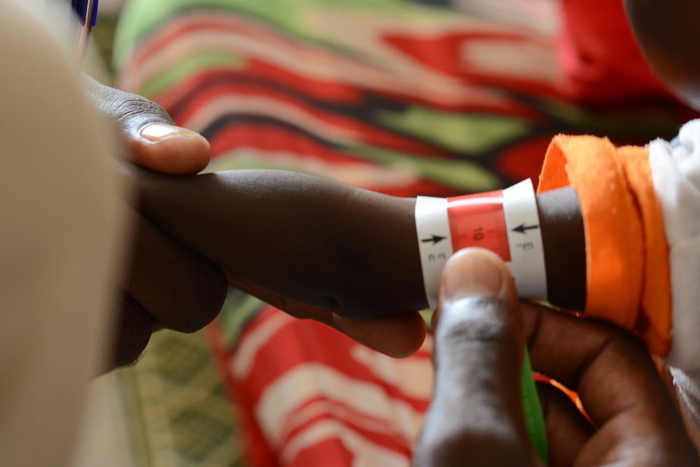 Un enfant subit un dépistage MUAC à l'ATFC de la clinique MSF du camp de Zamzam, au Darfour du Nord, une étape cruciale dans le diagnostic de la malnutrition.