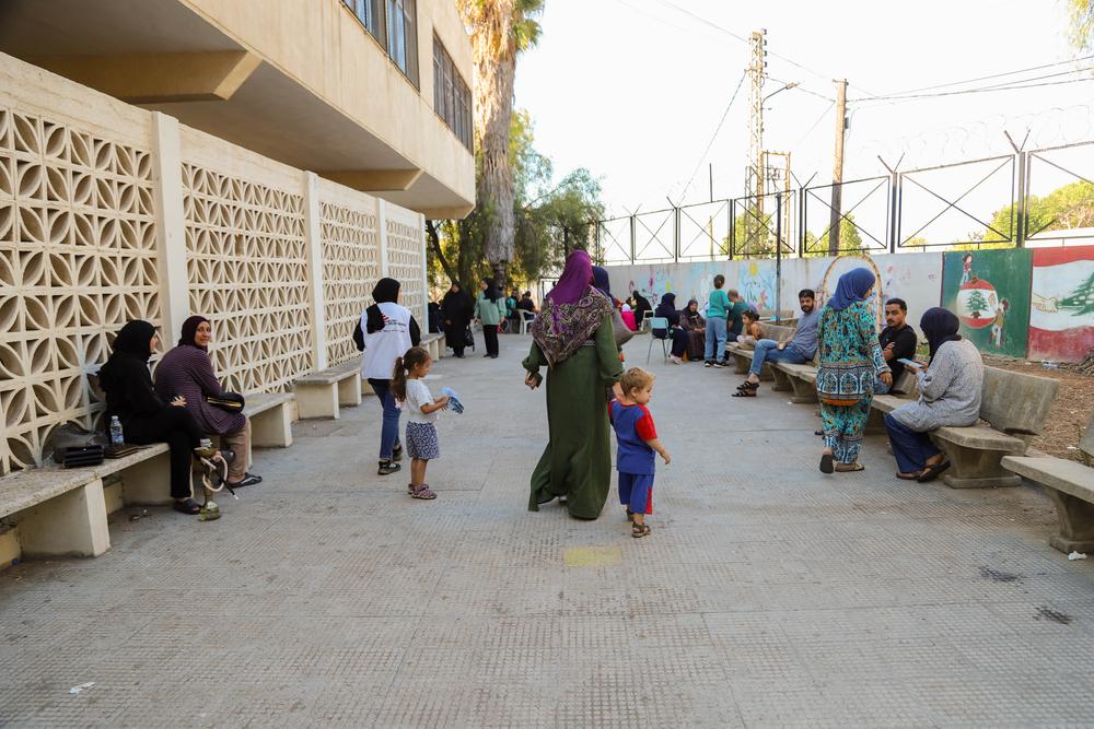 Les personnes déplacées se rassemblent dans la cour de l’école tandis que le personnel de MSF les informe des services de la clinique mobile.