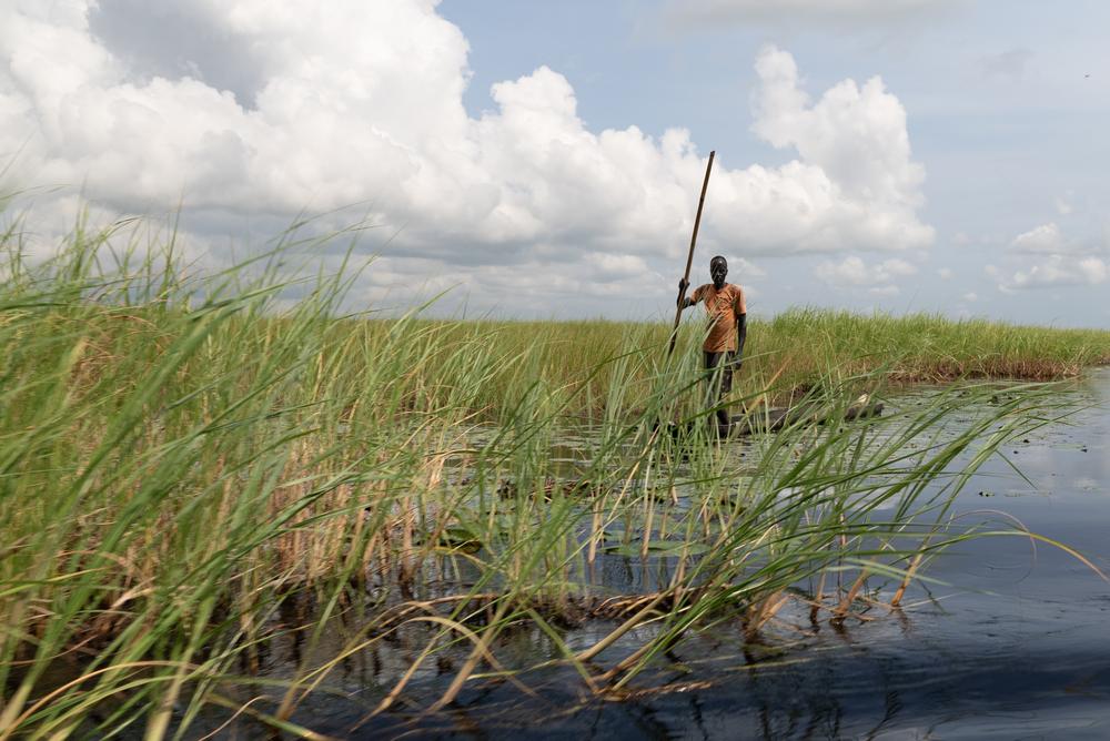 Un homme debout sur un canoë près de la ville d'Old Fangak.