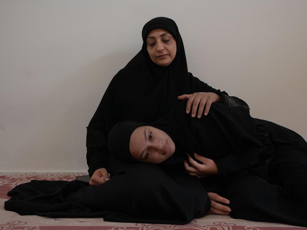 Ezdihar al Diqa, 39 ans, et sa fille Nouraya, 14 ans, dans la chambre qu’elles partagent depuis le 29 septembre avec 14 autres personnes dans le camp de déplacés d'Azariye dans le centre de la capitale libanaise. © Antoni Lallican/Hans Lucas