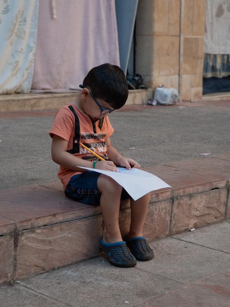 Un enfant dessine lors d'une activité organisée par le personnel de MSF dans le refuge d'Azarieh. Beyrouth, Liban, 11 octobre 2024. © Antoni Lallican/Hans Lucas