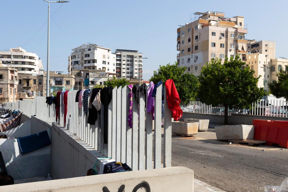 Des vêtements appartenant à des réfugiés syriens sont suspendus aux barreaux métalliques entourant un parking de la ville de Saïda