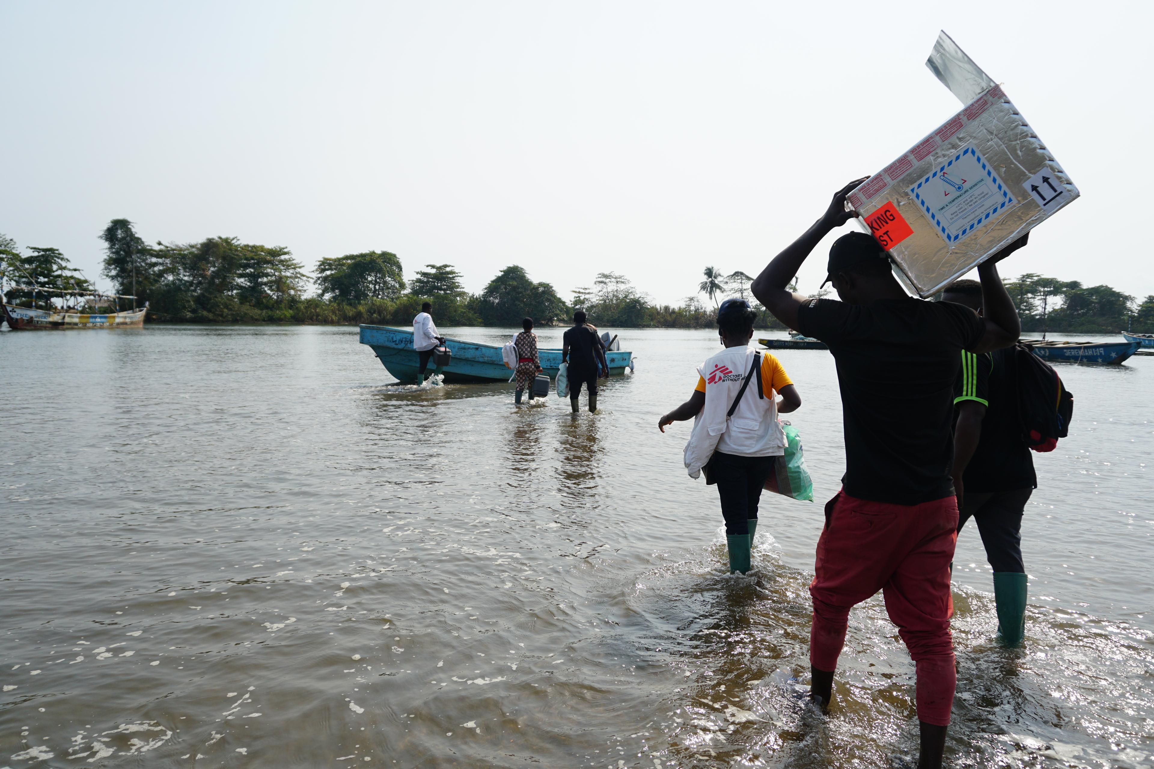 Une équipe MSF composée d'un coordinateur d'urgence, d'un superviseur DMC, d'un responsable de la communication et de volontaires de santé communautaire, lors d'une traversée en bateau depuis le village d'Enyenge où ils ont vacciné 419 personnes et se dirigent maintenant vers le port d'Idenau.