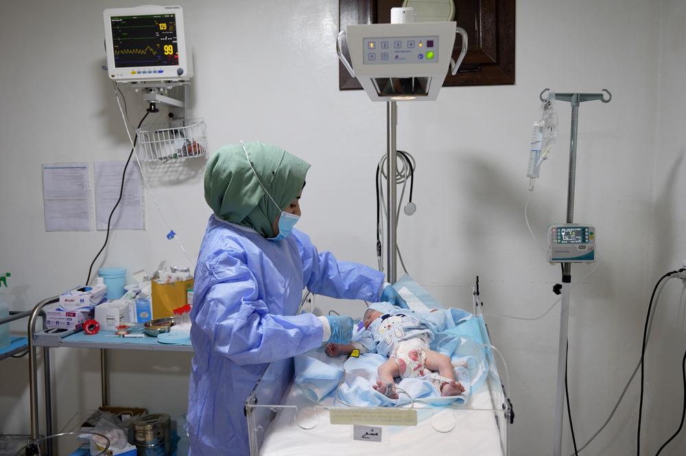 Une infirmière MSF à la maternité Marée examine un nouveau-né dans l'unité néonatale de l'hôpital.