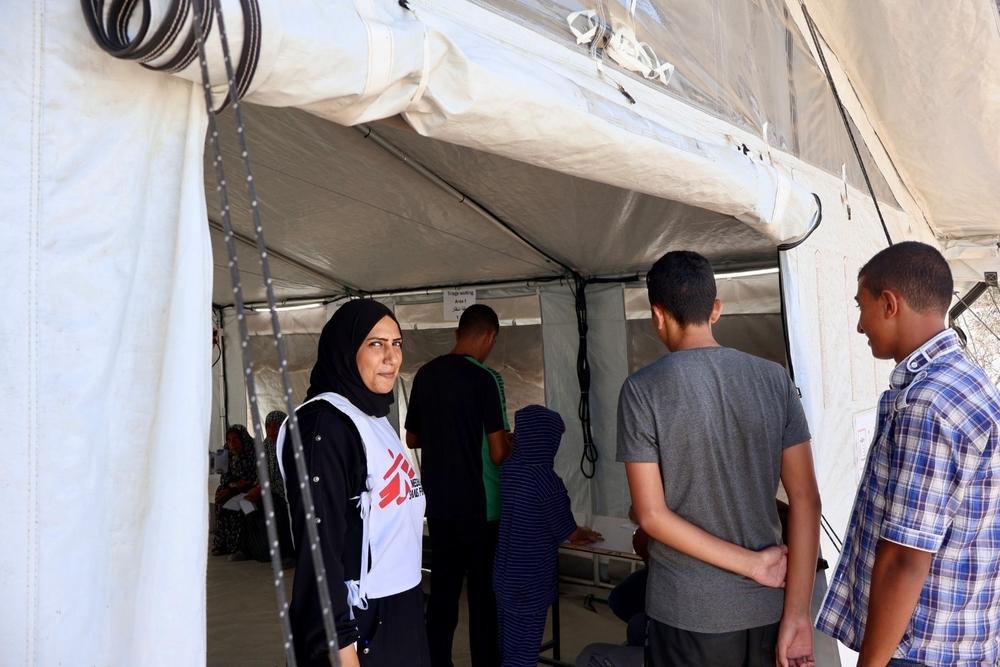 Ibtissam Nasser, gardienne de MSF, surveille l'entrée de l'hôpital de campagne.