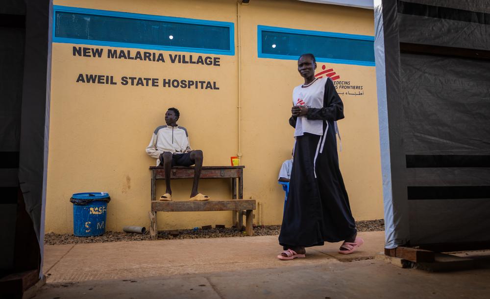 Un patient est assis à côté d'un mur du nouveau service de lutte contre le paludisme à l'hôpital d'État d'Aweil