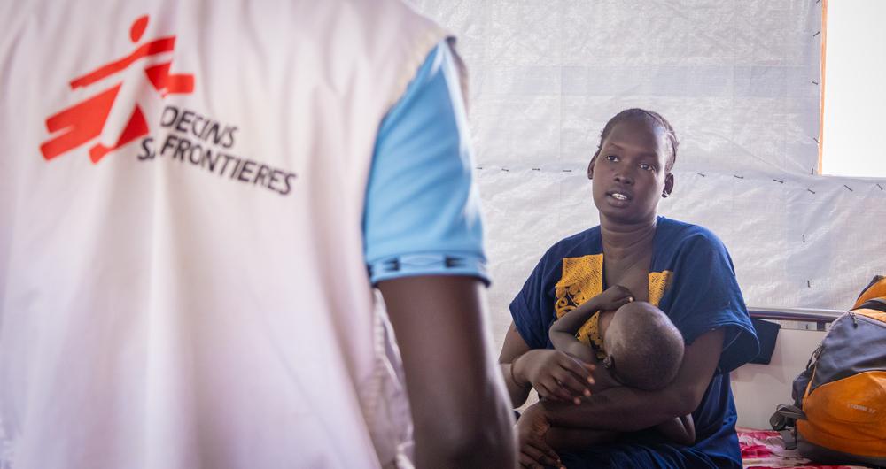 Abuk Gum discute avec un médecin lors d'un examen de routine dans le nouveau service de lutte contre le paludisme du village. Son bébé d'un an a été admis à l'hôpital pour pneumonie et paludisme.