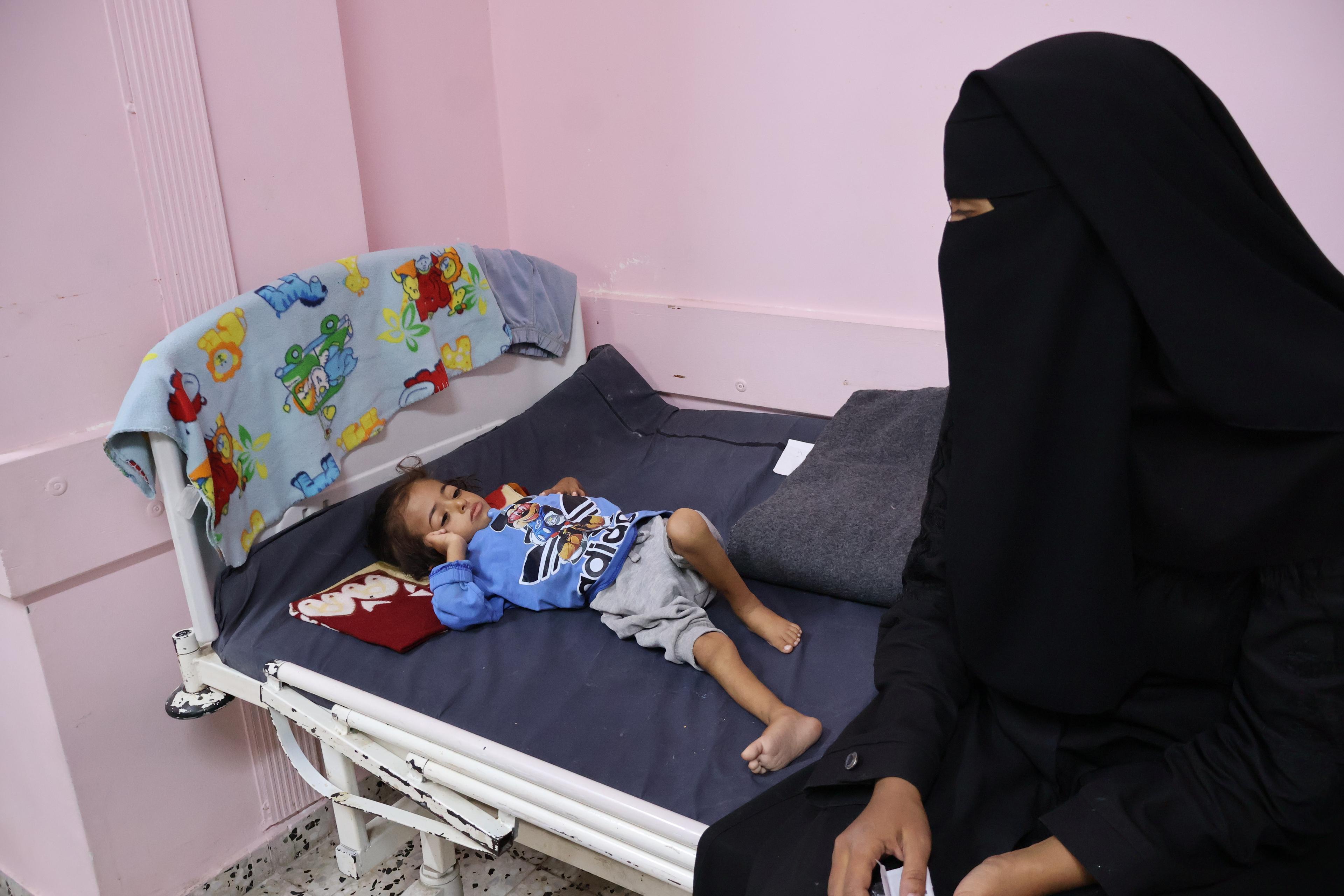 Une mère est assise avec son enfant mal nourri à l'hôpital Nasser soutenu par MSF.