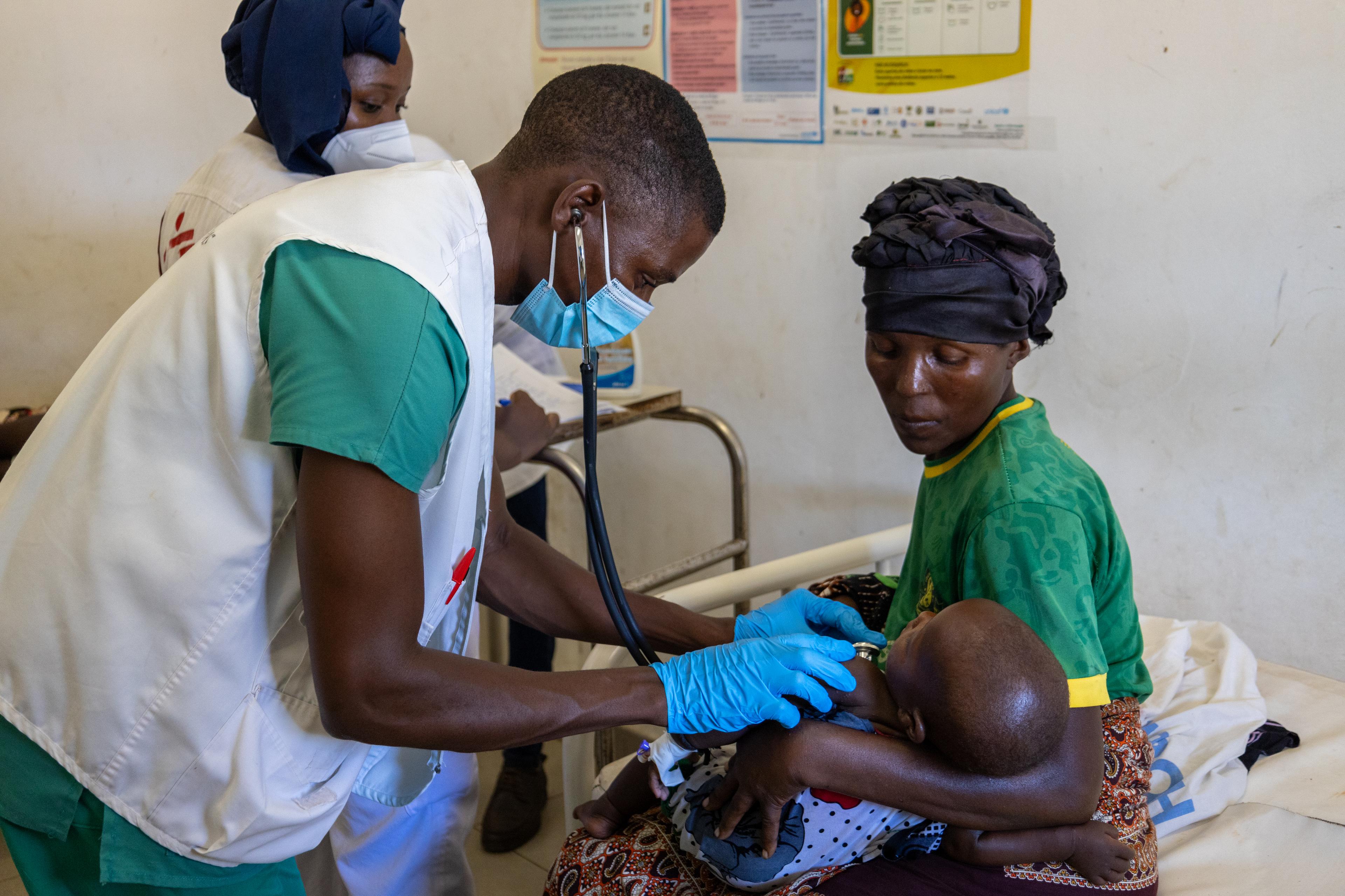 Manuel João, technicien médical MSF, examine une patiente venue chercher des soins pour son enfant au centre de santé de Palma, dans le nord du Mozambique, que MSF soutient depuis 2021.