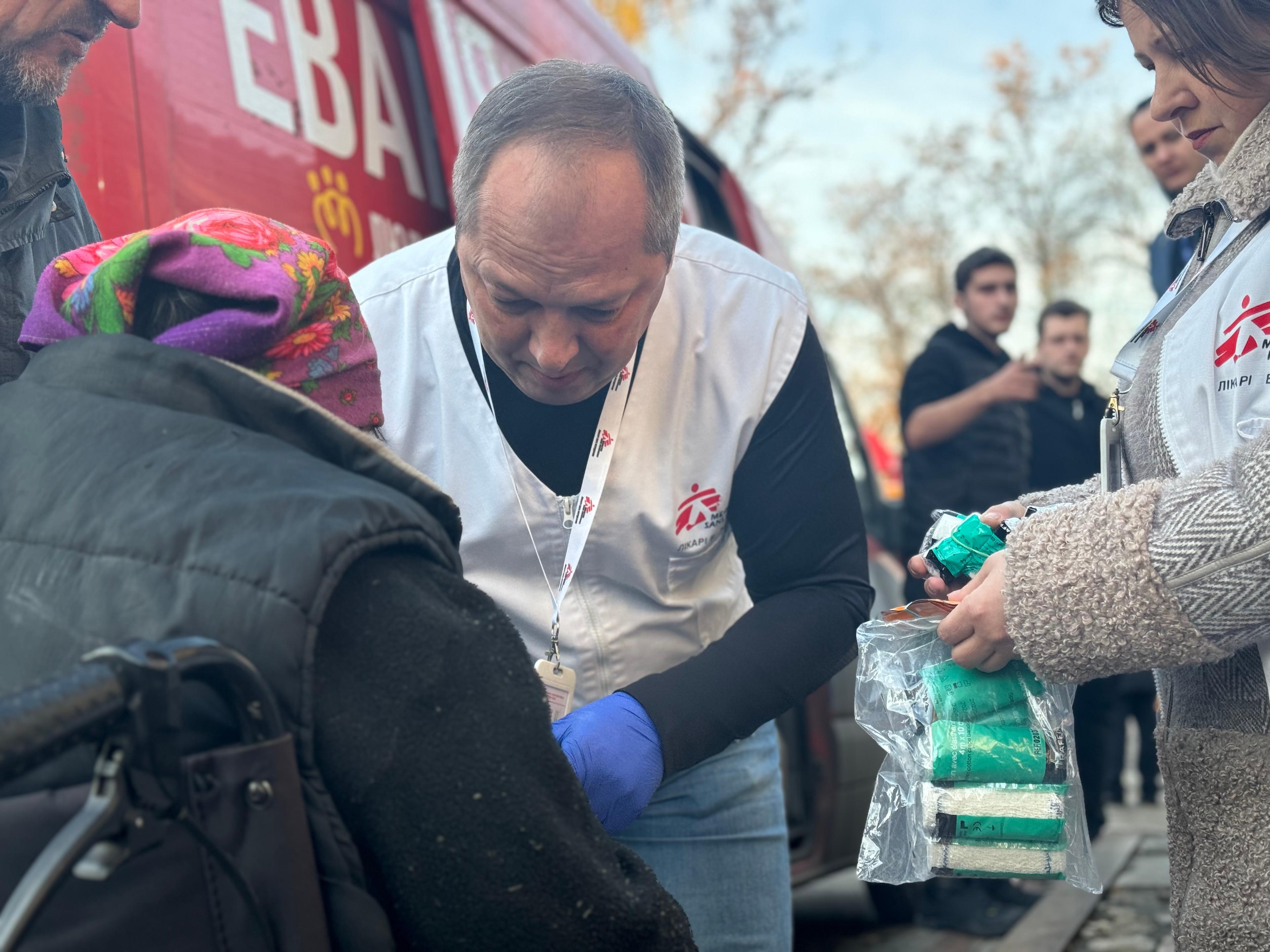 MSF doctor Oleksandr Hontariev performs an initial surgical treatment on the arm of a patient (a wound debridement, removing dead tissue and cleaning the wound) near the transit centre for people fleeing the war, Pavlohrad, Dnipropetrovsk region.
