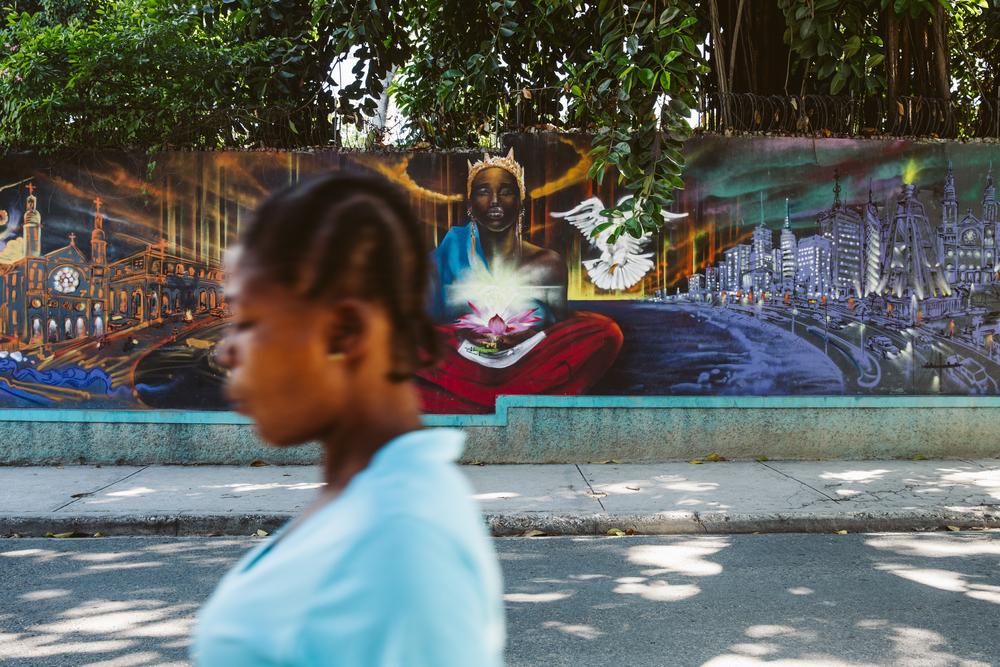 Une femme passe devant une peinture murale à Bois-Verna, un quartier résidentiel de Port-au-Prince.