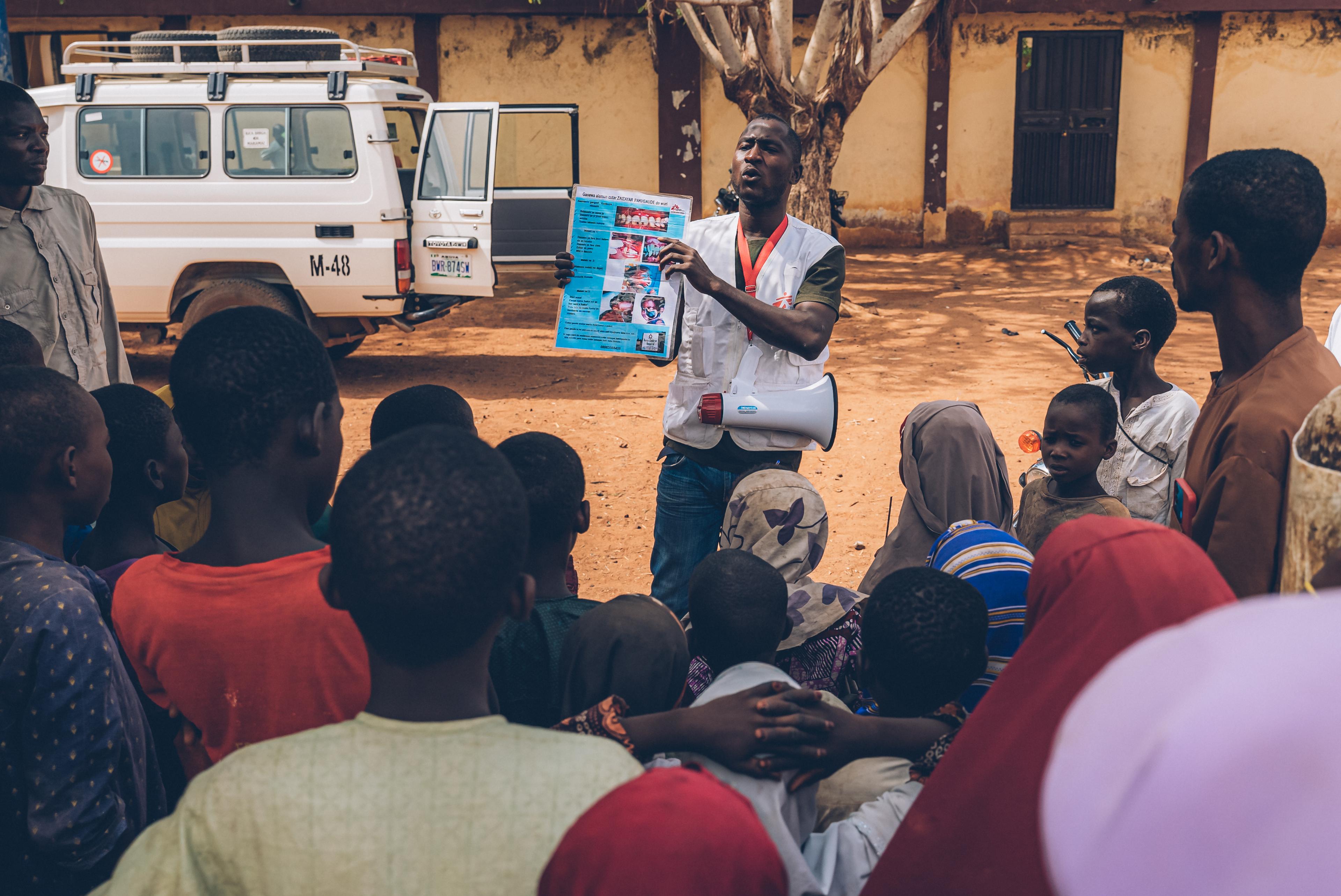 L'équipe de sensibilisation de l'hôpital Noma de Sokoto, au Nigéria, a commencé en janvier 2017 à rechercher activement des cas dans l'État de Sokoto. Ici, dans le village de Sayinna, l'équipe montre des dépliants pour vérifier si quelqu'un identifie un cas de noma dans la région. Ils informent également les gens sur les causes du noma et la possibilité de le traiter à ses débuts. Ce jour-là, un cas précoce de noma a été détecté et un rendez-vous a été fixé pour une visite à l'hôpital. 6 mai 2023.