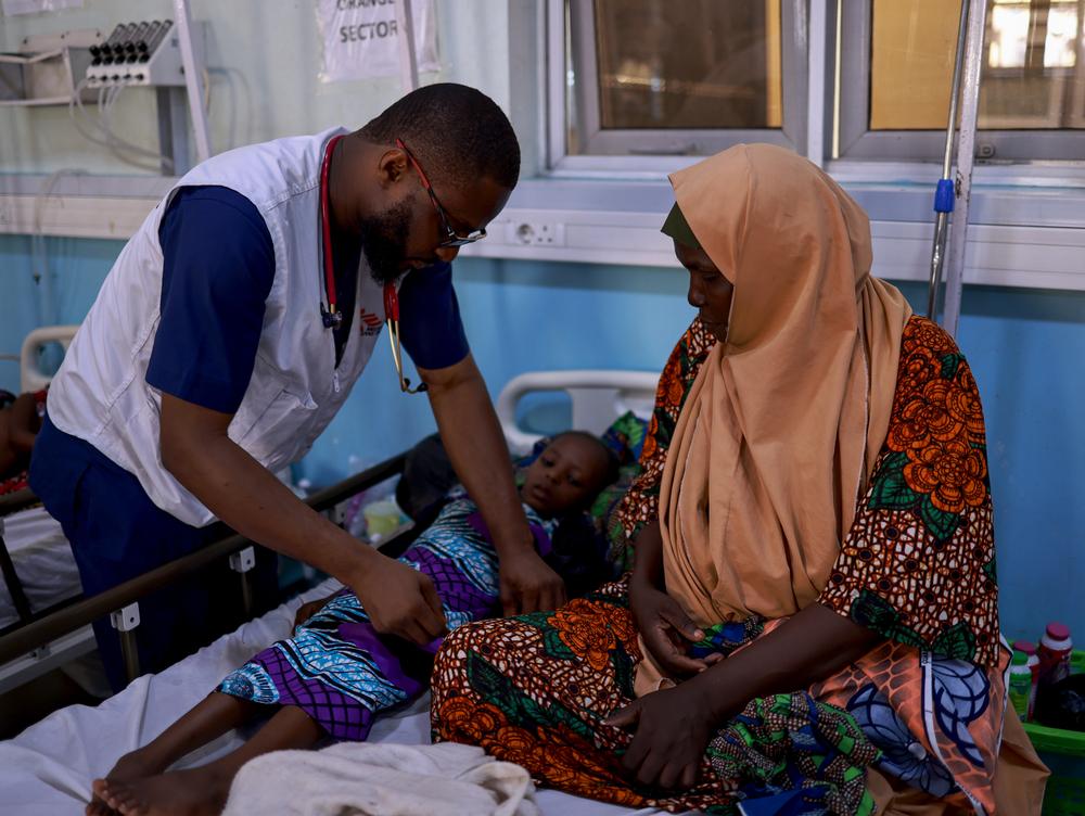 Le Dr Firima examine Fatima Mustapha, soignée pour un paludisme grave au centre de soins de santé primaires de Gwange, soutenu par MSF, à Maiduguri, dans le nord-est du Nigéria. 