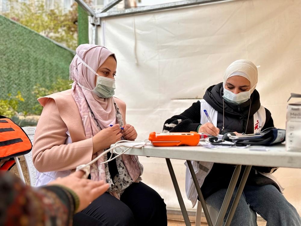 Le personnel de MSF enregistre les informations des patients avant de les guider à l'intérieur de la clinique