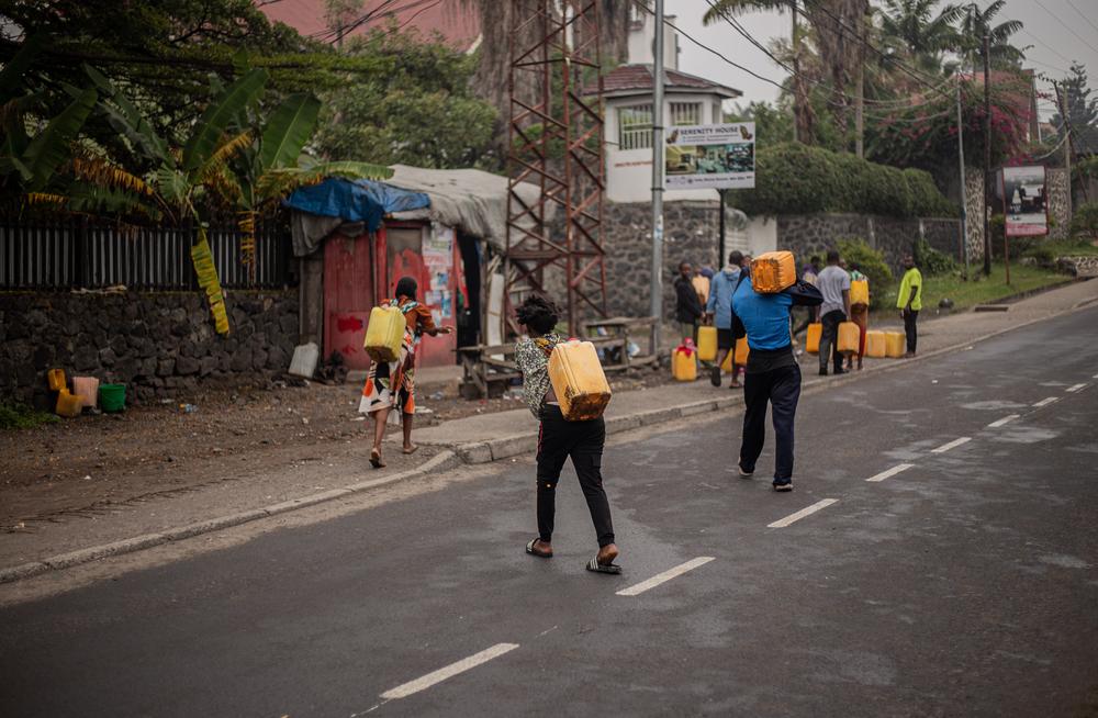 Des habitants de Goma transportent des jerrycans d'eau potable alors que la ville est soumise à des interruptions du service d'eau. © Jospin Mwisha