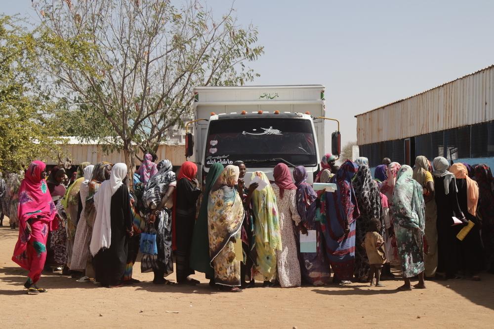 Un groupe de personnes fait la queue pour recevoir le premier lot de nourriture et de fournitures médicales dans le cadre d'un programme de distribution alimentaire ciblé de Médecins Sans Frontières (MSF)