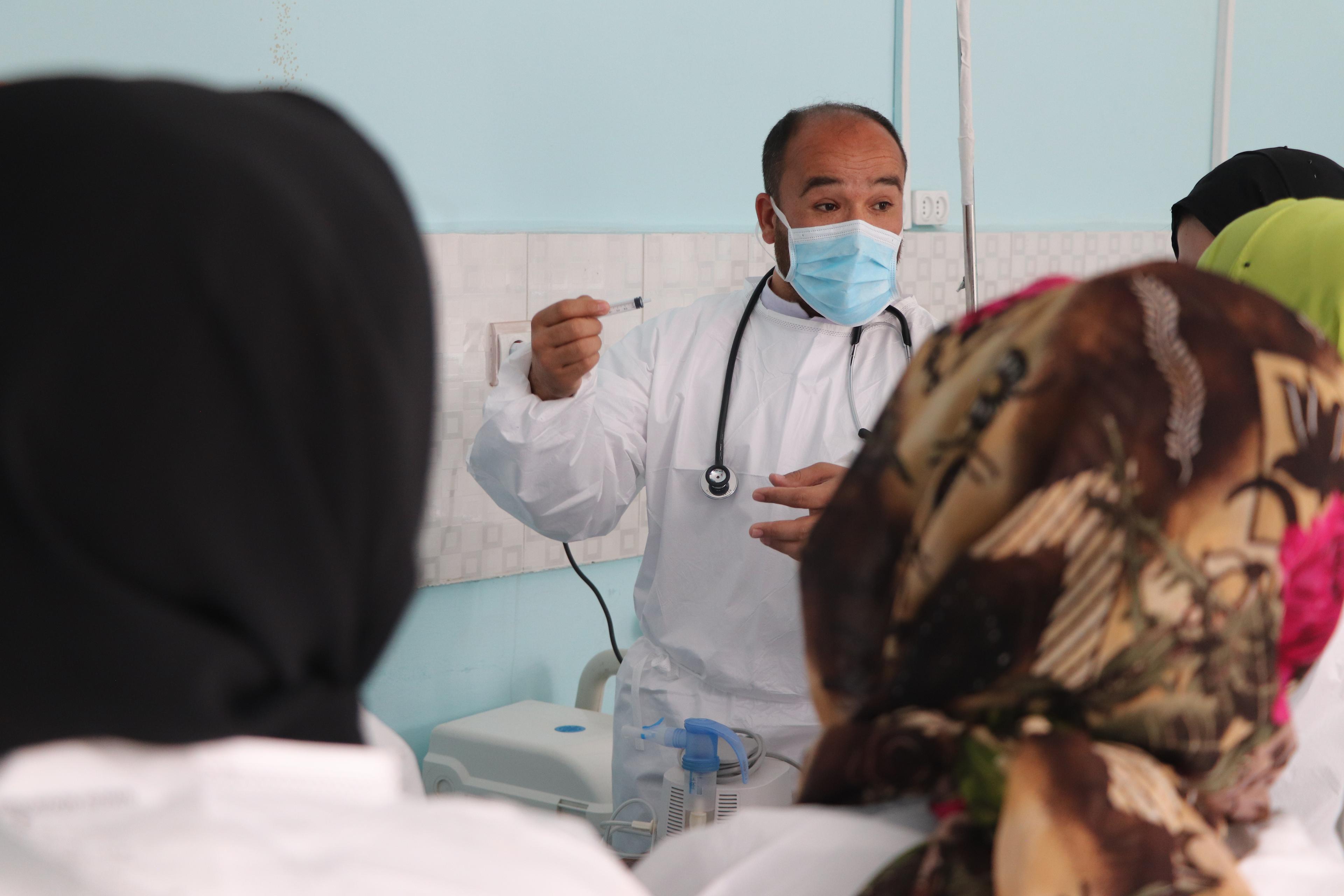 Le Dr Mohammad Qahir Poya, chef du service d'isolement de la rougeole, montre quelques infirmières du service, soutenu par MSF à l'hôpital régional de Mazar-i-Sharif, dans la province de Balkh. © Tasal Khogyani/MSF