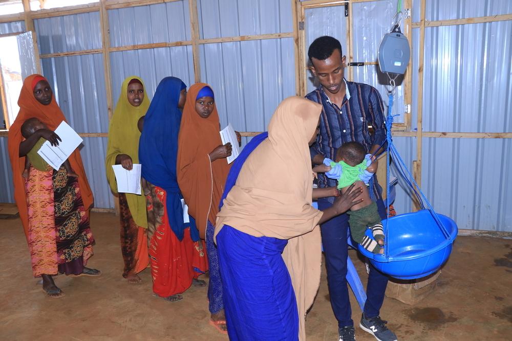 Des mères font la queue pour mesurer le poids de leurs enfants dans un centre de proximité décentralisé soutenu par MSF près du camp de déplacés d'Afmadow. Juin, 2024 © Bishar Mayow/MSF